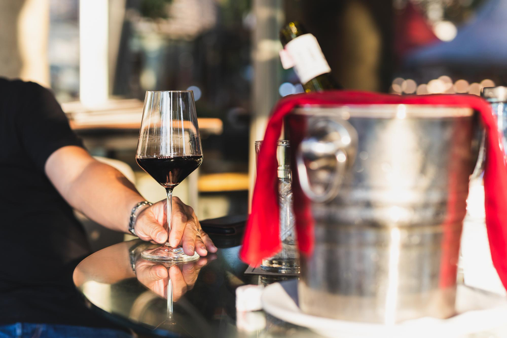 un homme à table avec un verre et une bouteille de vin