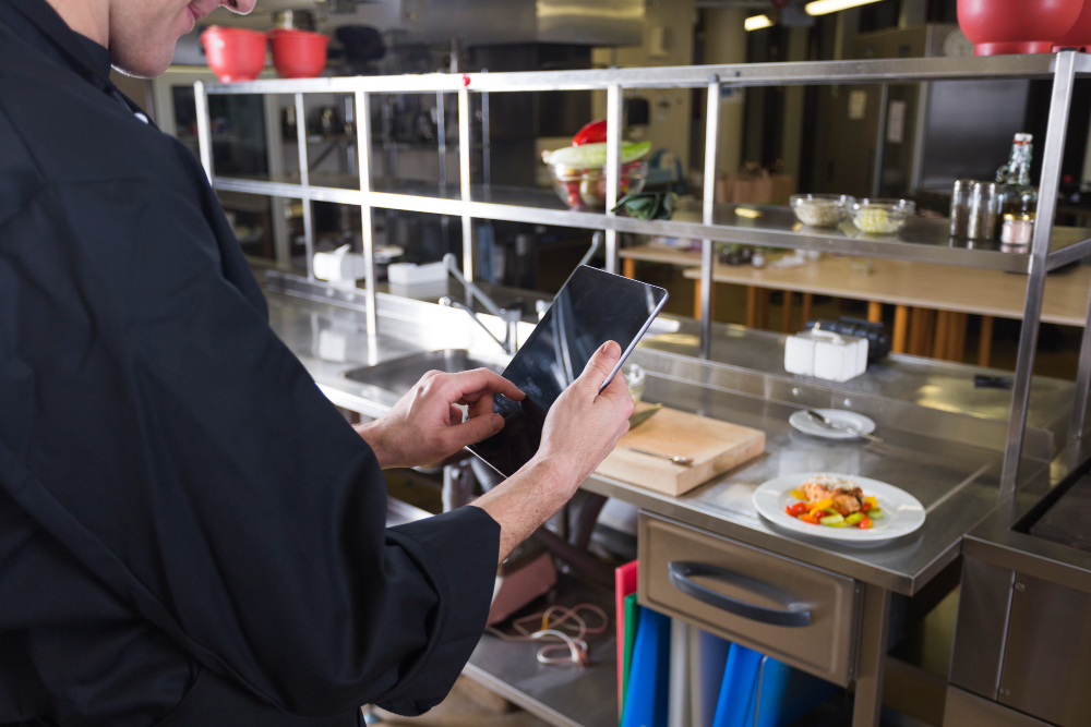 un chef faisant une photo d'un de ses plats au restaurant